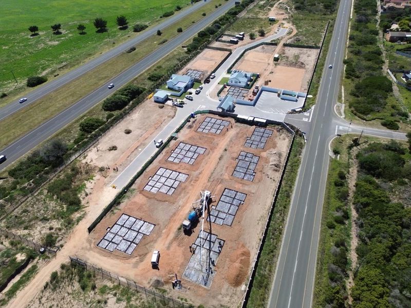 Aerial view of a residential development site showing multiple concrete foundations laid out for new housing construction.
