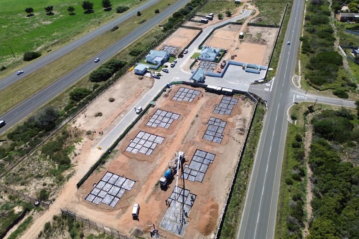 Aerial view of a residential development site showing multiple concrete foundations laid out for new housing construction.