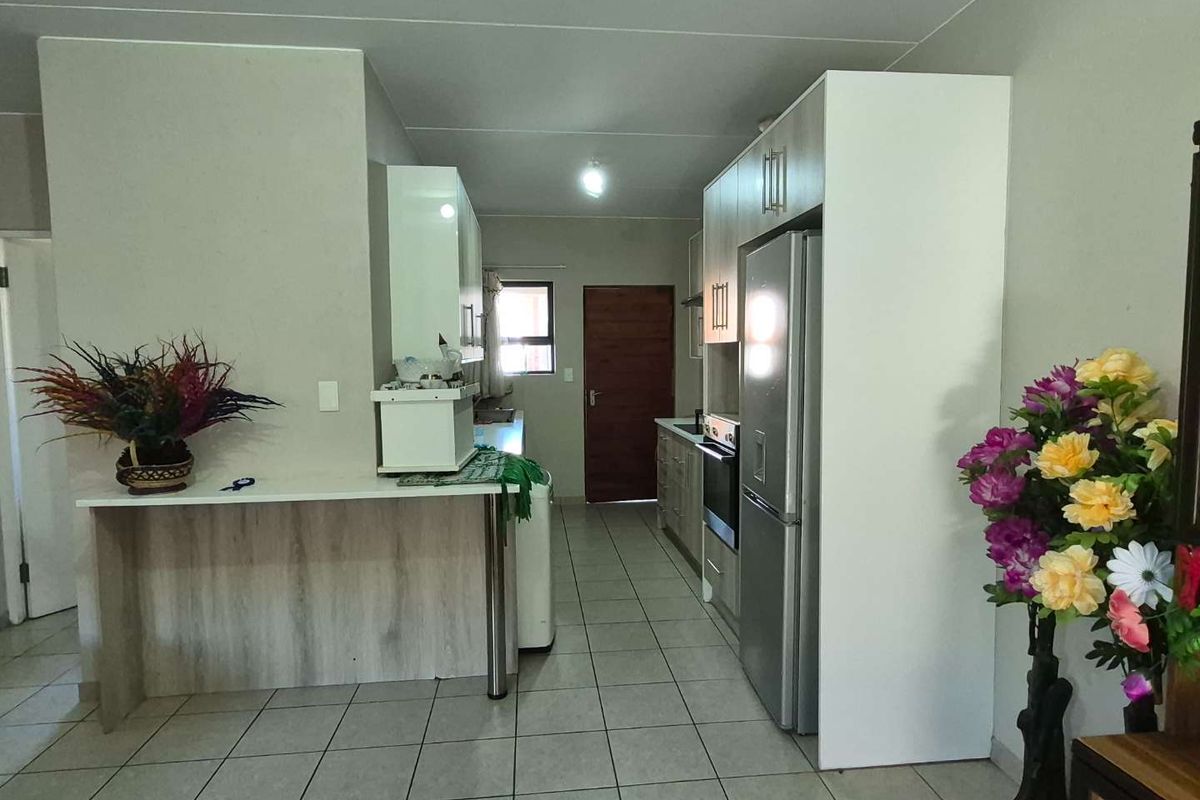 A functional kitchen featuring tiled flooring, built-in cabinetry, a breakfast bar, and integrated appliances, offering a practical layout for daily use.