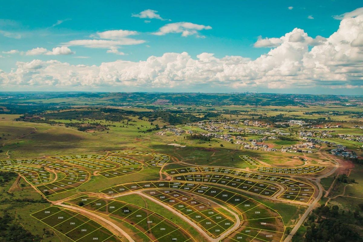 An aerial view of a large residential land development site showing subdivided plots and surrounding landscape.