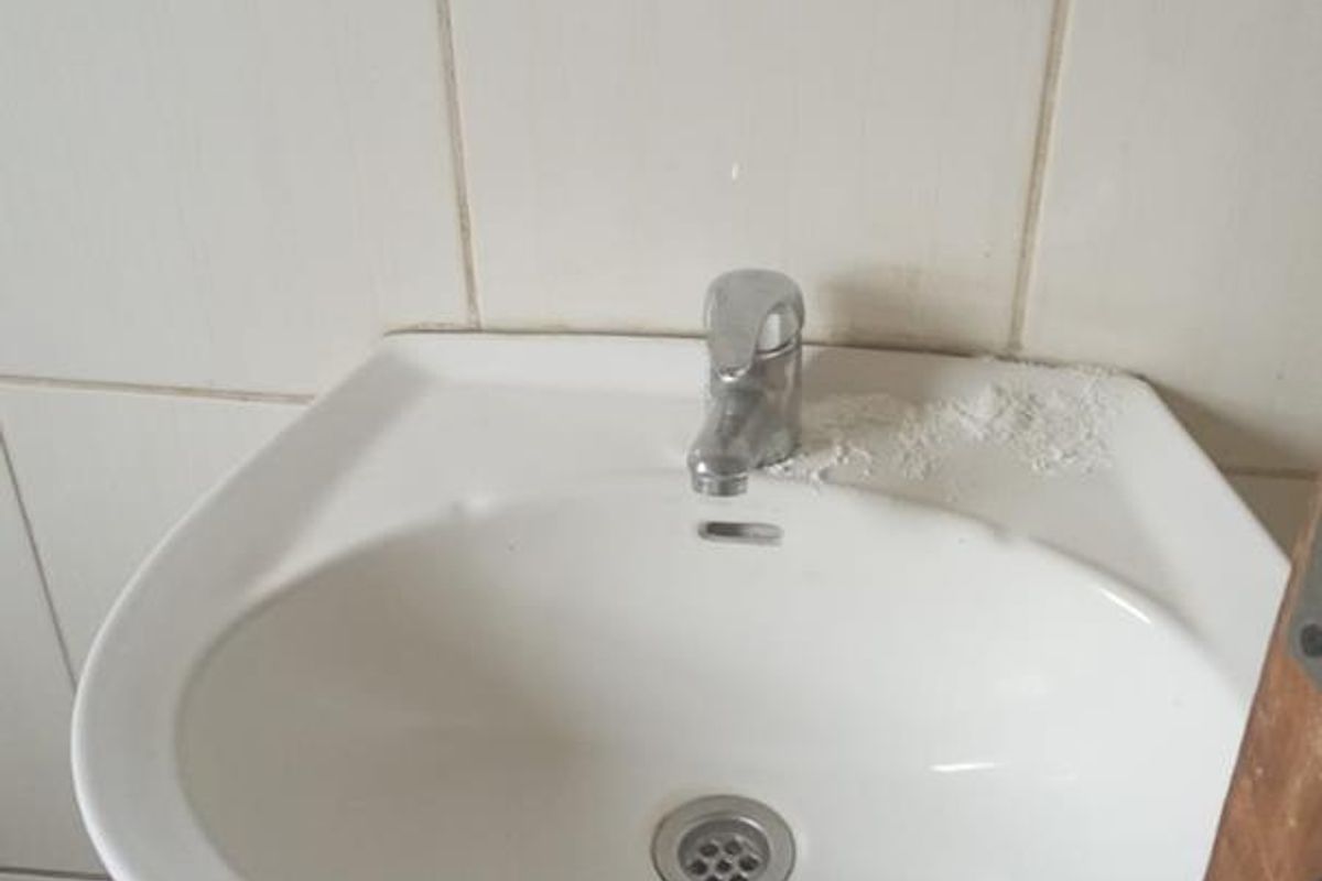 A functional pedestal basin with a chrome mixer tap, featuring tiled wall splashbacks in a standard bathroom setting.