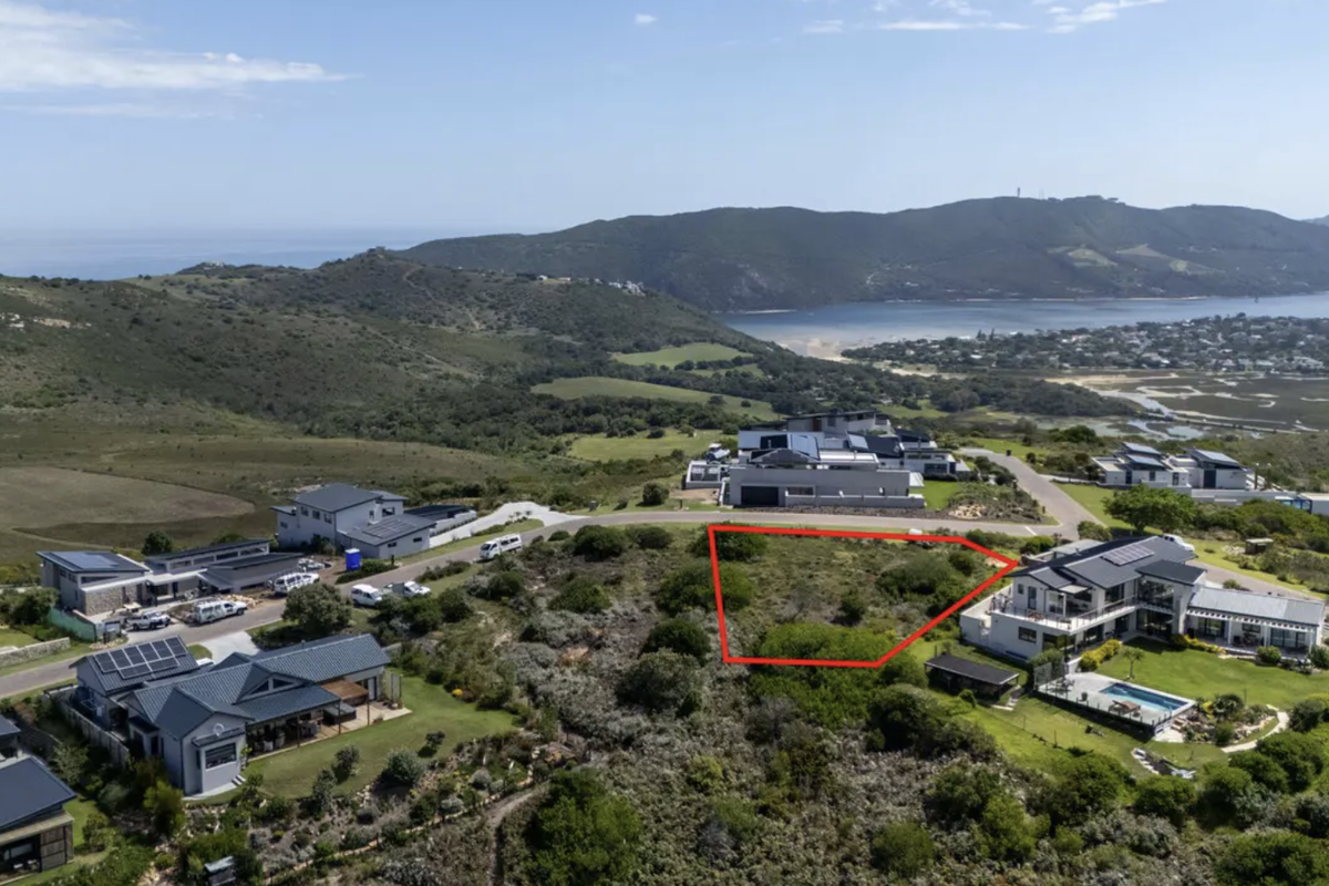 Aerial view of a vacant residential plot in a coastal estate, highlighting the surrounding landscape and proximity to the estuary and ocean.