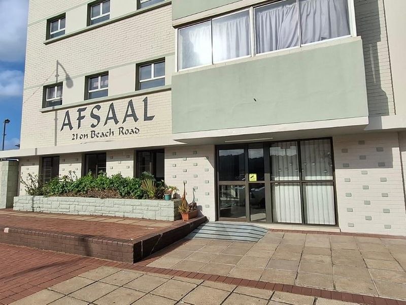 Front exterior view of Afsaal building on Beach Road, featuring a paved entrance, raised planter box, and secure gated access.
