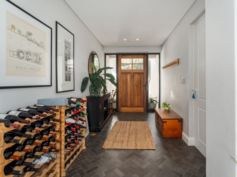 Welcoming entrance hall featuring dark herringbone tile flooring, recessed lighting, and a solid timber front door with side light panels.