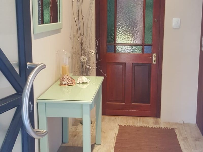 A welcoming entrance hall featuring tiled flooring and a classic timber front door with decorative stained glass panels.