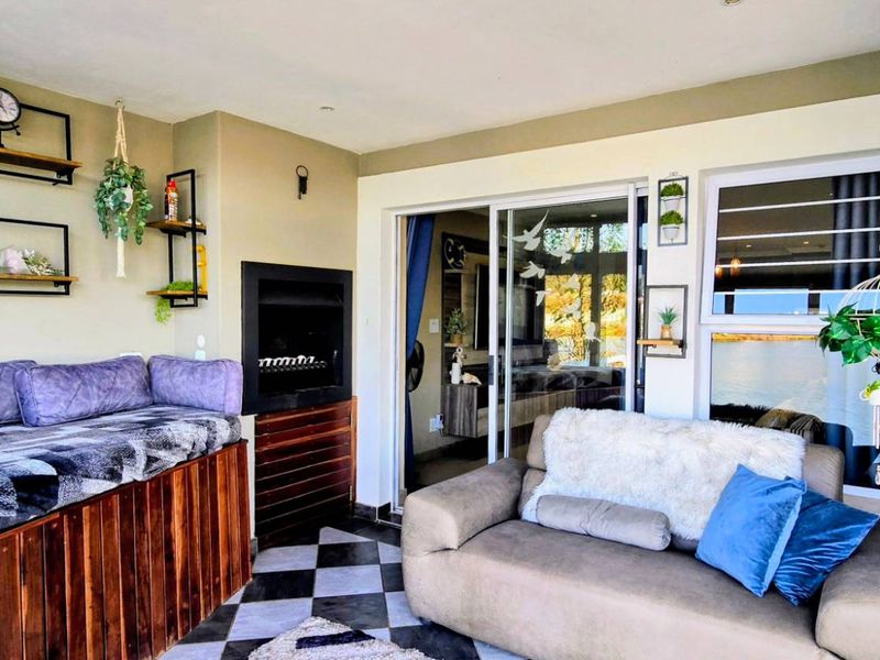 Covered patio area featuring a built-in fireplace, tiled flooring, and large sliding glass doors providing access to the interior living space.