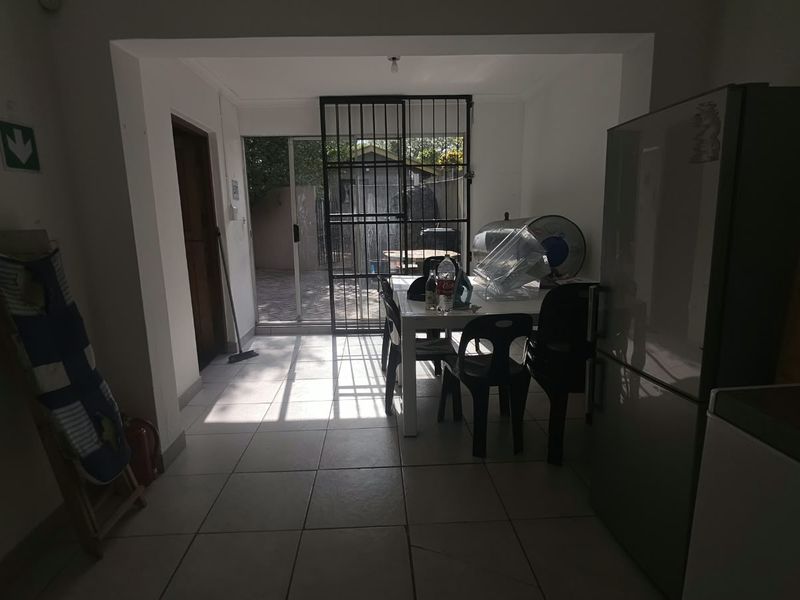 Open plan living area featuring tiled flooring and direct access to an outdoor patio through a secure sliding glass door.