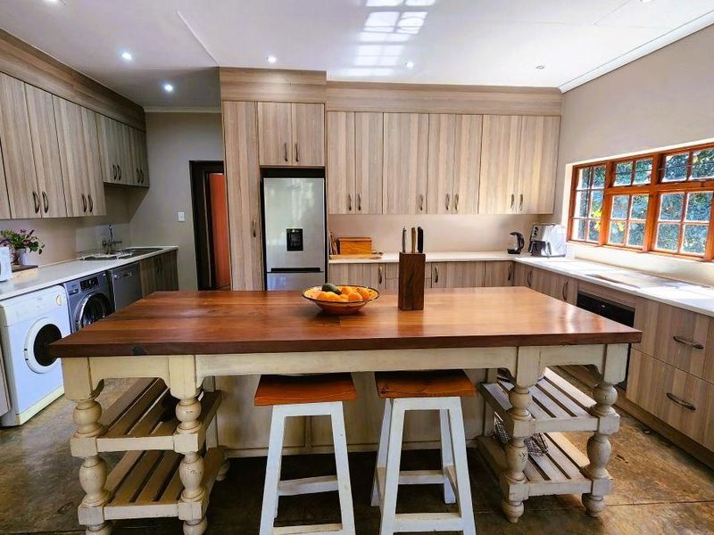 Spacious kitchen featuring extensive built-in cabinetry, ample counter space, a large central island, and natural light from a wide window.