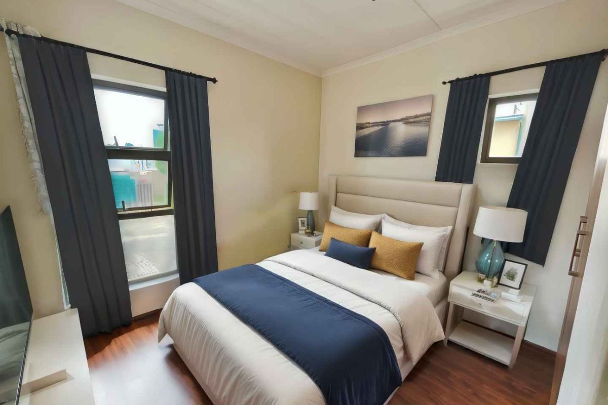 A well-maintained bedroom featuring laminate flooring, coved ceilings, and dual casement windows, providing a comfortable and functional living space.