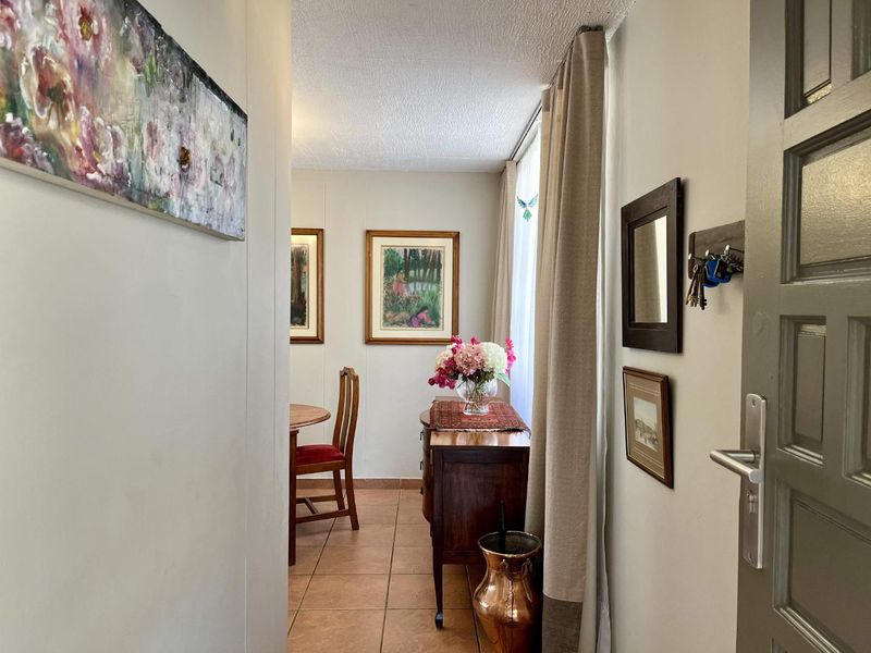 A view from the entrance into a dining area featuring tiled flooring and natural light from a large window.