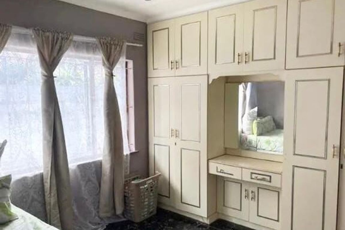 Bedroom featuring extensive built-in cabinetry with an integrated vanity unit and recessed ceiling lighting.