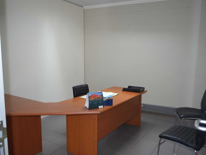 A functional office space featuring tiled flooring and a neutral wall finish, suitable for a professional work environment.
