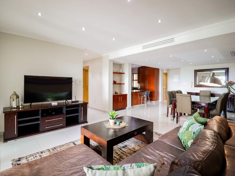 Spacious open-plan living and dining area featuring tiled floors, recessed lighting, ducted air conditioning, and integrated kitchen cabinetry.
