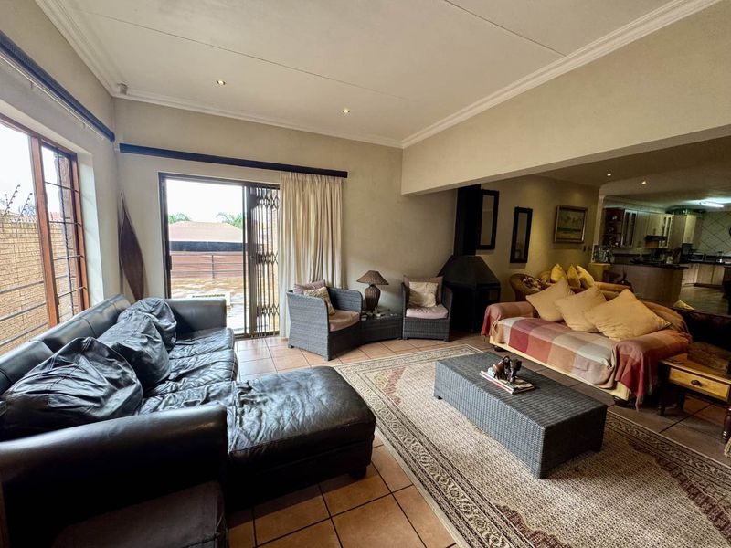 Spacious open-plan living area featuring tiled floors, a built-in fireplace, and sliding door access to the outdoor patio.