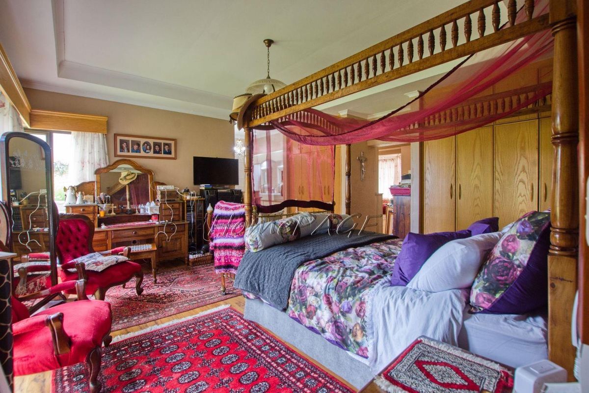 Spacious bedroom featuring built-in wooden cabinetry and a tray ceiling design.