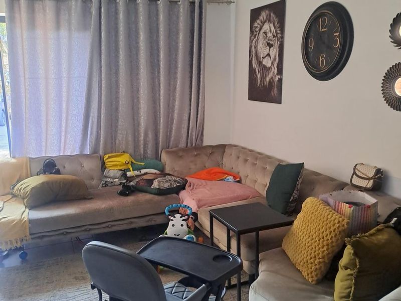 A living room area featuring tiled flooring and window treatments, providing a functional space for relaxation.