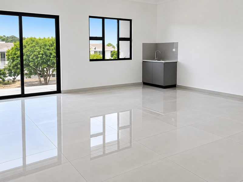 Modern, bright office space featuring polished porcelain tiles, a convenient kitchenette, and large sliding glass doors providing ample natural light and outdoor access.