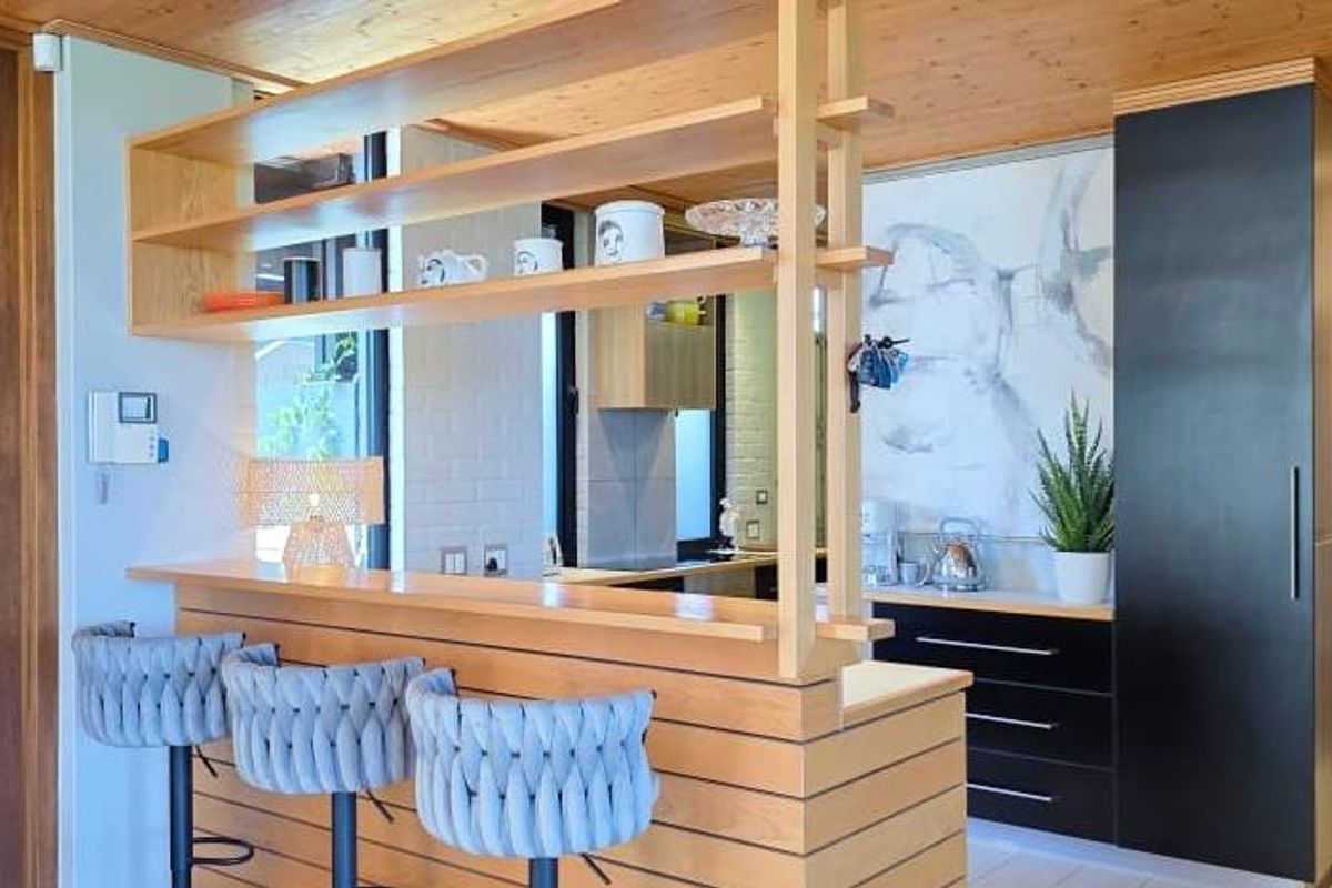 Modern kitchen featuring a timber breakfast bar, integrated cabinetry, and warm timber ceiling finishes, creating a functional and stylish culinary space.