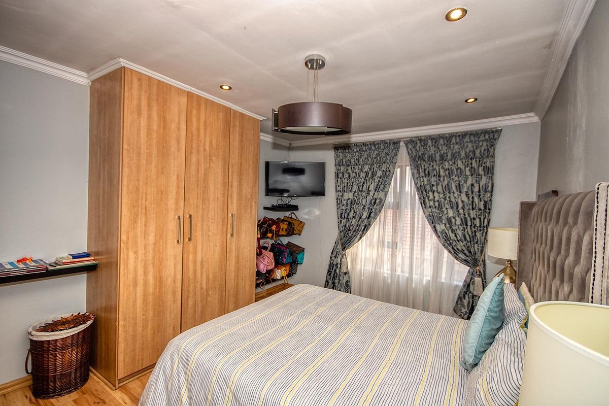 A bedroom featuring built-in wooden cabinetry, recessed ceiling lighting, and crown molding, providing functional storage and a comfortable living space.