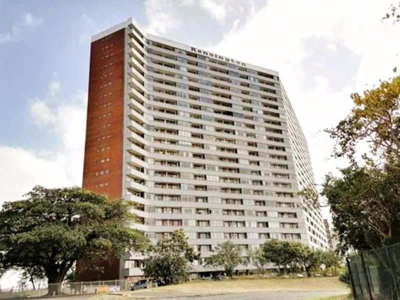 A view of the Kensington apartment building, showcasing its multi-story residential facade with integrated balconies and brick architectural detailing.