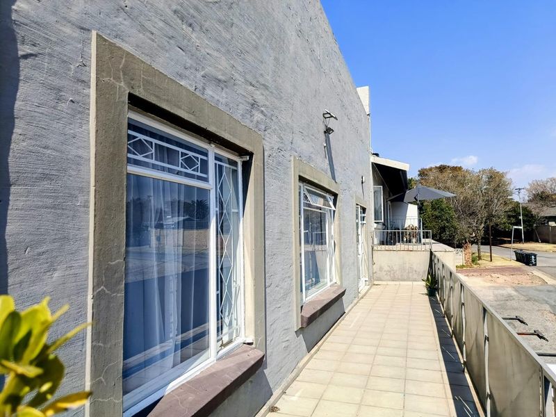 A spacious exterior balcony featuring tiled flooring and metal balustrades, providing an outdoor area accessible from the apartment's living spaces.
