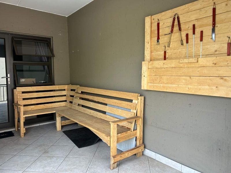 Covered patio area featuring tiled flooring and direct access to the interior through an aluminium framed door.