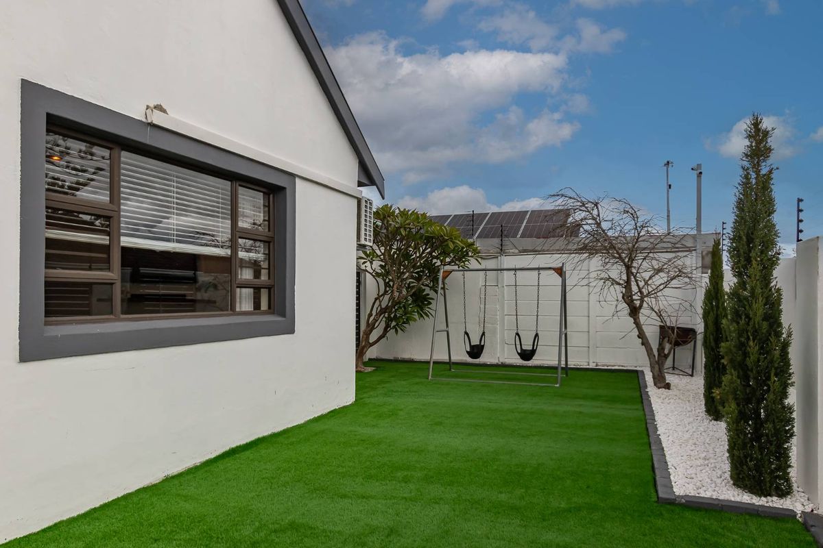 A well-maintained rear garden featuring artificial turf, perimeter walling, and established landscaping, providing a clean and low-maintenance outdoor space.