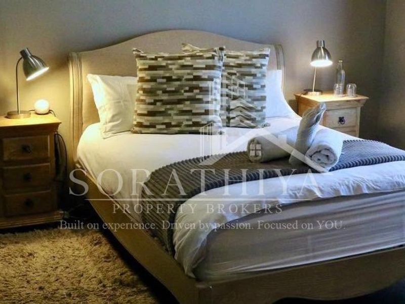 A cozy bedroom featuring laminate flooring and neutral wall tones, providing a comfortable and inviting sleeping space.