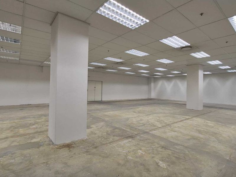 A large, open-plan retail space featuring a suspended ceiling, recessed lighting, and exposed concrete flooring, suitable for various commercial fit-out configurations.