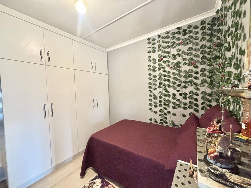 A bedroom featuring floor-to-ceiling built-in cupboards and light-toned flooring, offering practical storage space.