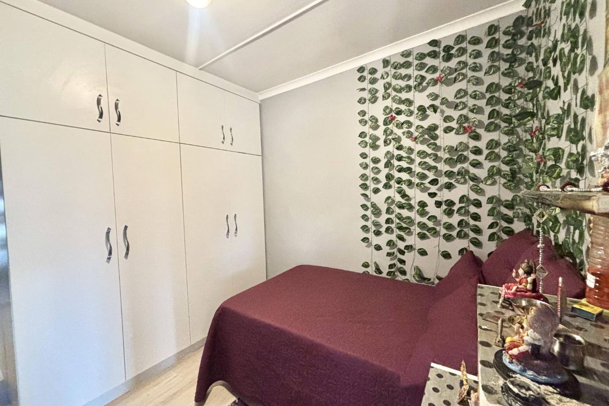 A bedroom featuring floor-to-ceiling built-in cupboards and light-toned flooring, offering practical storage space.