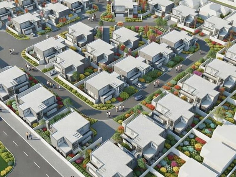 An aerial view of a modern residential estate featuring multiple housing units, paved internal roads, and landscaped garden areas.