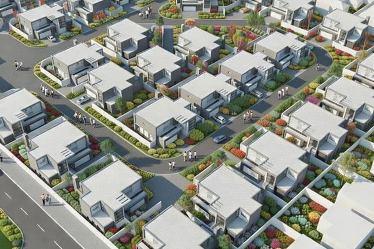 An aerial view of a modern residential estate featuring multiple housing units, paved internal roads, and landscaped garden areas.