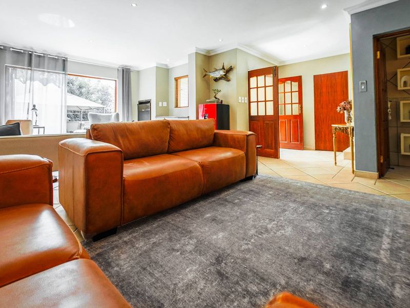 Spacious living room featuring tiled flooring, recessed downlights, and large sliding glass doors providing natural light and access to the outdoor area.