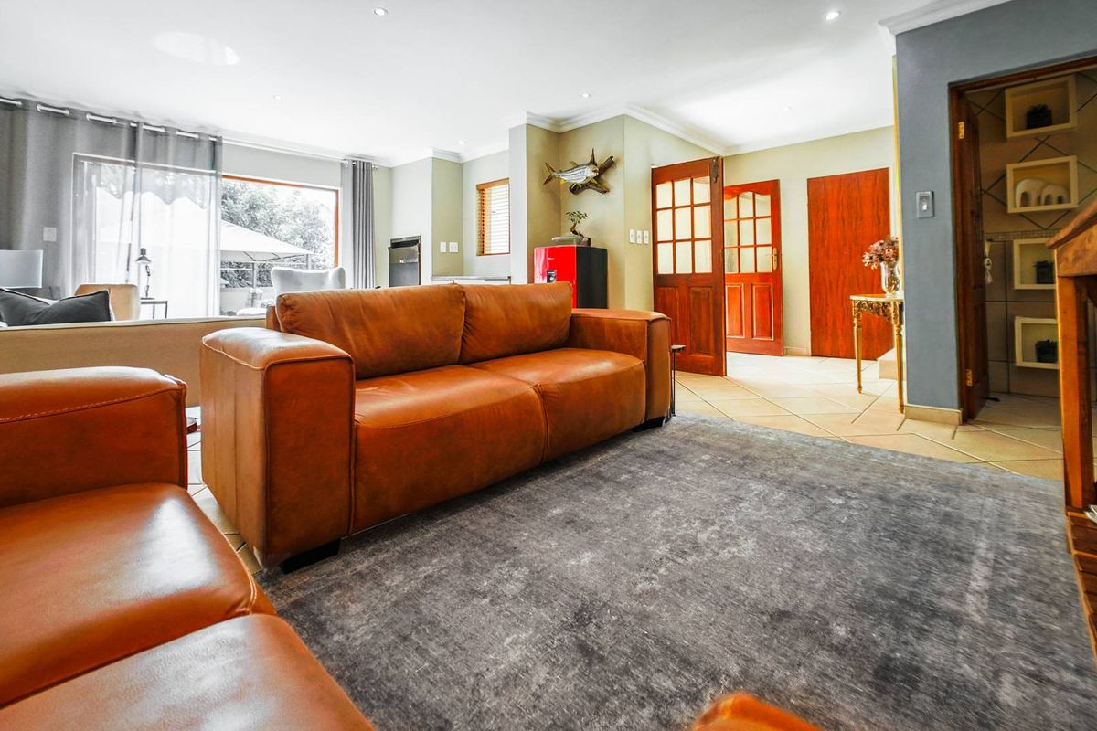 Spacious living room featuring tiled flooring, recessed downlights, and large sliding glass doors providing natural light and access to the outdoor area.