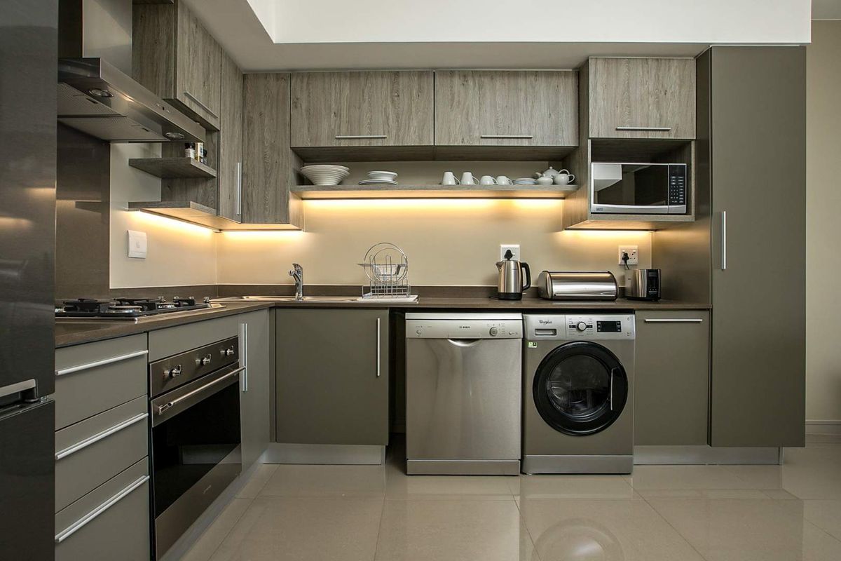 Modern kitchen featuring sleek cabinetry, integrated appliances, under-cabinet lighting, and high-quality finishes, providing a functional and contemporary cooking space.