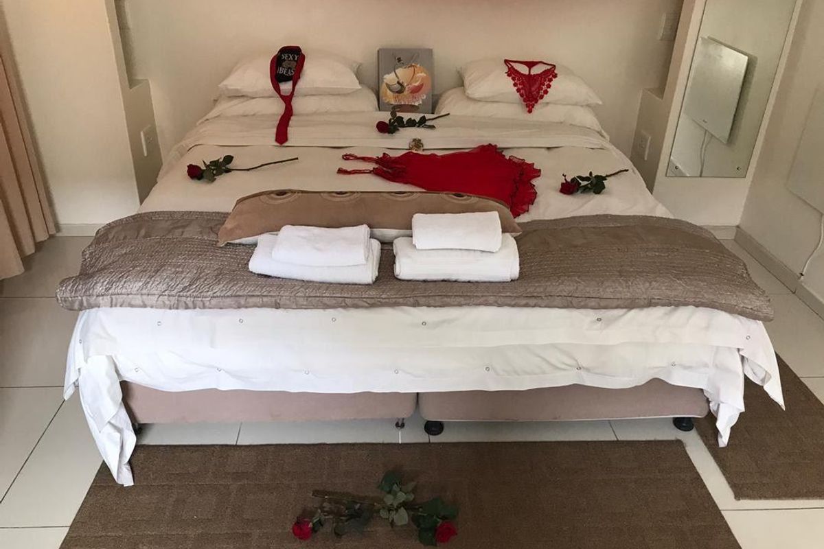 A bedroom featuring tiled flooring, built-in wall niches for storage, and a wall-mounted heater.