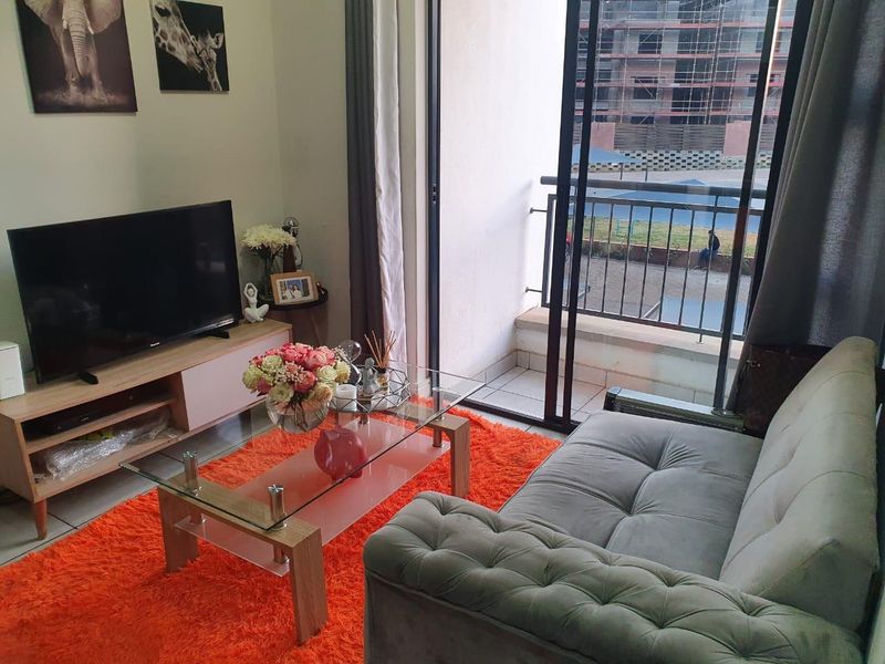 A comfortable living room featuring a sliding glass door that opens onto a private balcony with metal railings.