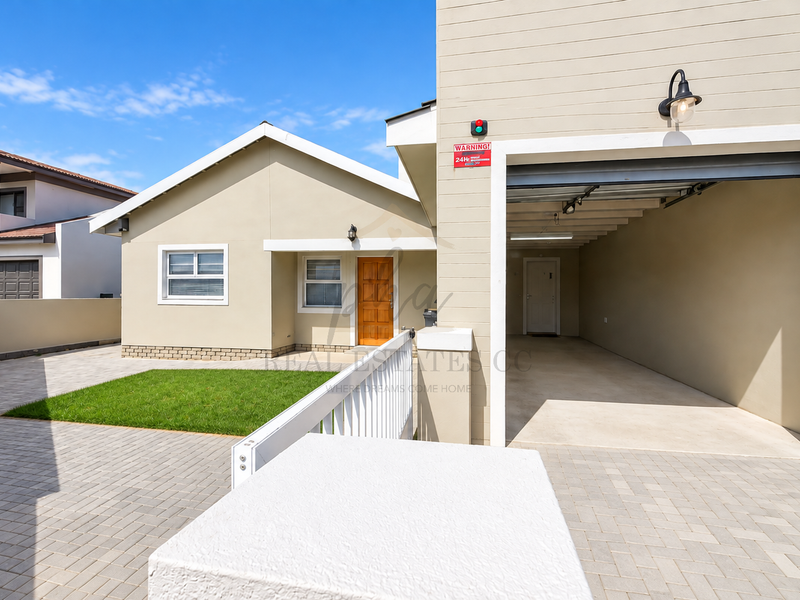 Front view of the property featuring a paved driveway, carport, well-maintained lawn, and a secure entrance with modern exterior finishes.
