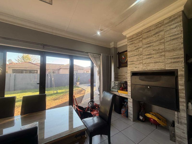 Living area featuring a built-in fireplace, tiled flooring, and large sliding glass doors providing direct access to the rear garden.