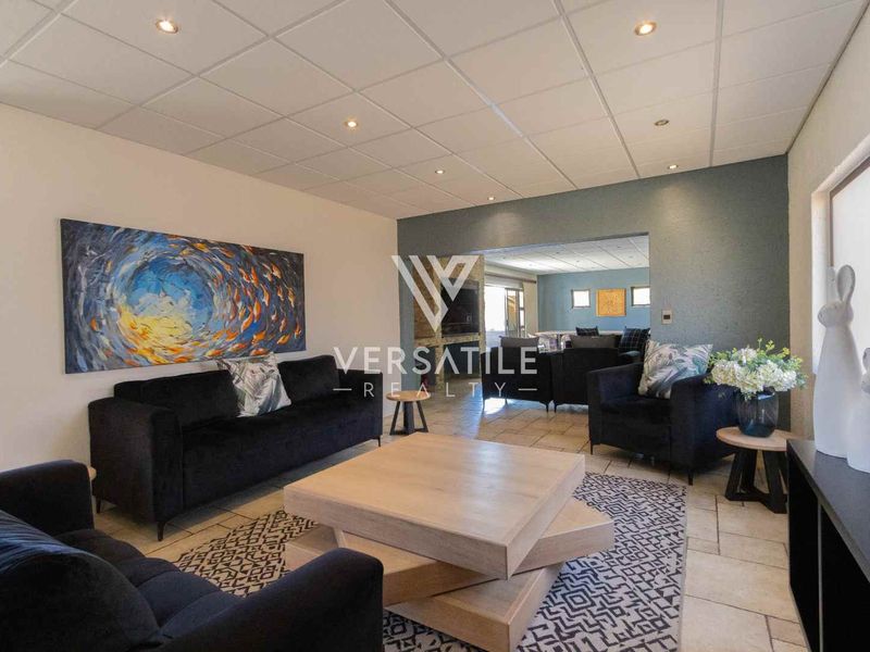A spacious living area featuring tiled flooring, recessed downlighting, and a drop ceiling, providing a comfortable and functional space for relaxation.