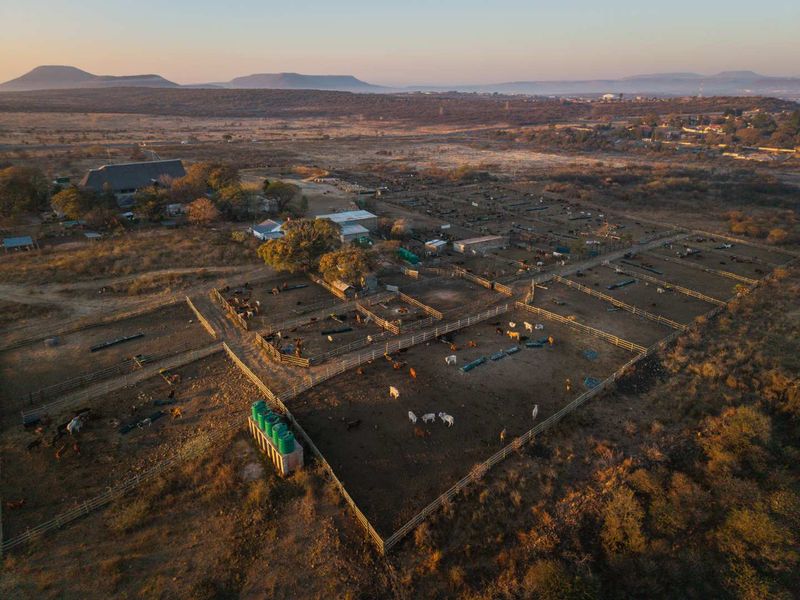 Aerial view of a large agricultural property featuring extensive livestock enclosures, cattle kraals, farm buildings, and water storage infrastructure.
