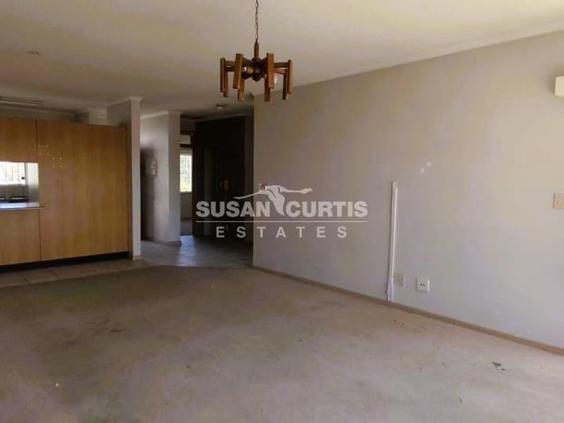 Spacious open-plan living area featuring a functional kitchen with built-in cabinetry and direct access to an outdoor patio area.