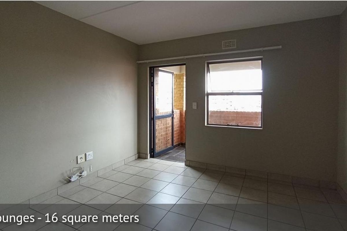An empty living room featuring tiled flooring, neutral wall paint, and direct access to an outdoor balcony area.