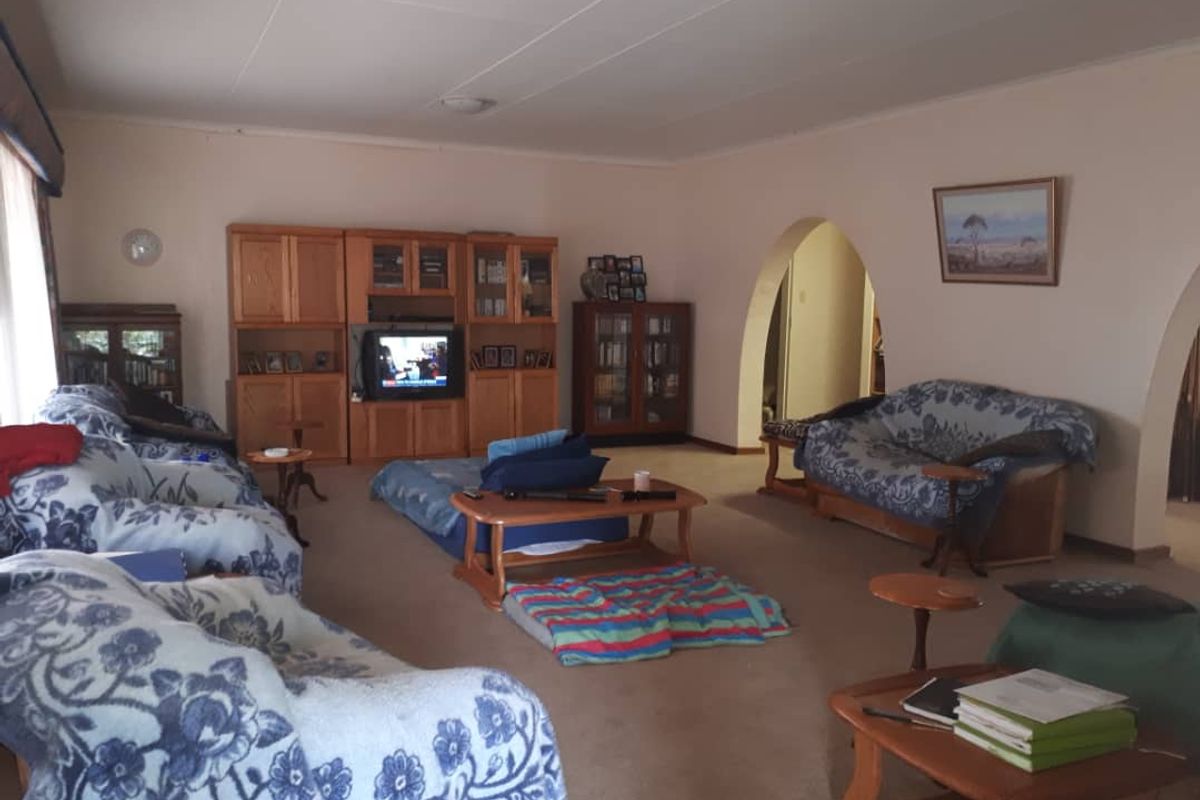Spacious living room featuring arched doorways and neutral wall finishes, providing a comfortable and traditional layout for family relaxation.