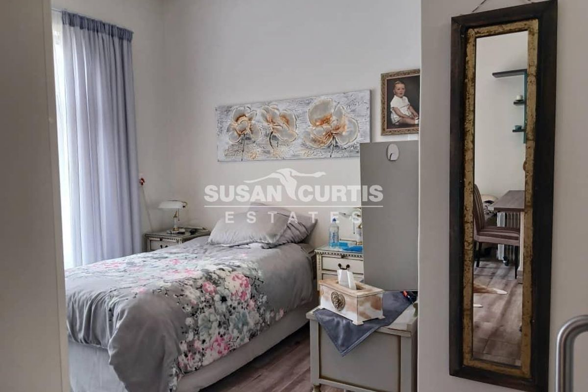 A cozy bedroom featuring laminate flooring and neutral wall finishes, offering a comfortable living space within the retirement village.