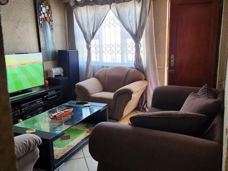 A living room featuring tiled flooring, a security gate, and an air conditioning unit, with visible wear on the wall finishes and ceiling.