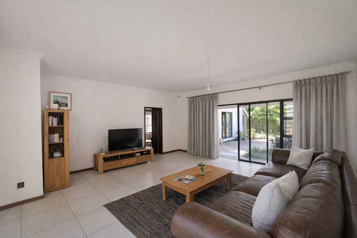 Spacious living room featuring large sliding glass doors that provide seamless access to the outdoor patio area.