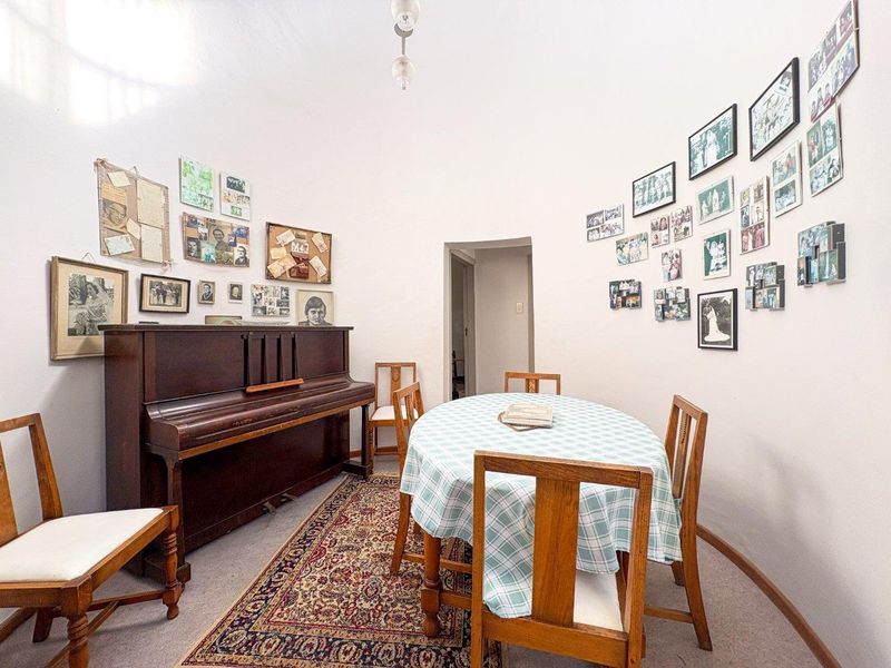 A dining room featuring a curved wall design, neutral carpeting, and a central ceiling light fixture.