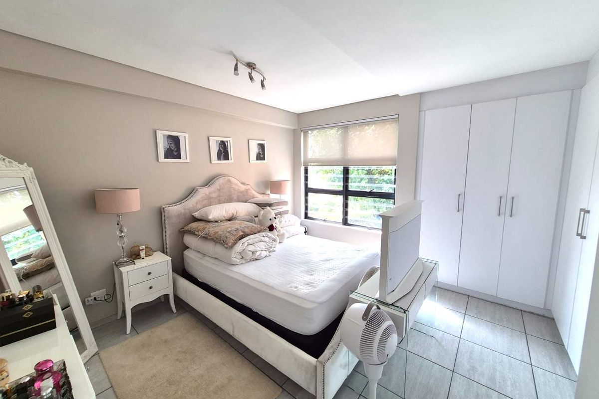 A well-maintained bedroom featuring neutral wall tones, tiled flooring, and ample built-in cupboard storage space.